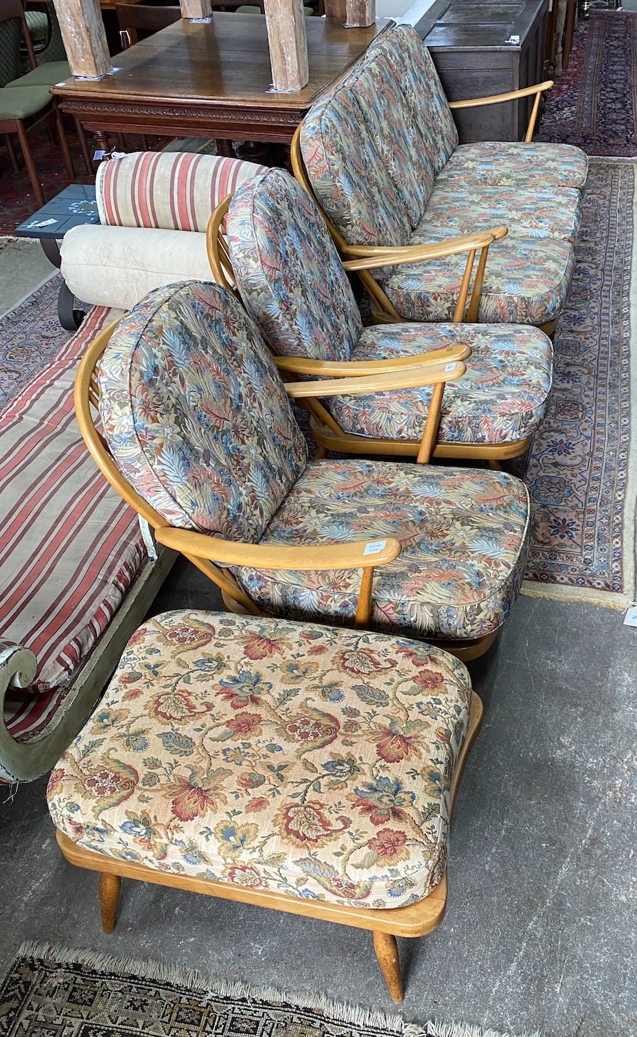 An Ercol beech three piece lounge suite and footstool, settee length 174cm, width 80cm, height 82cm